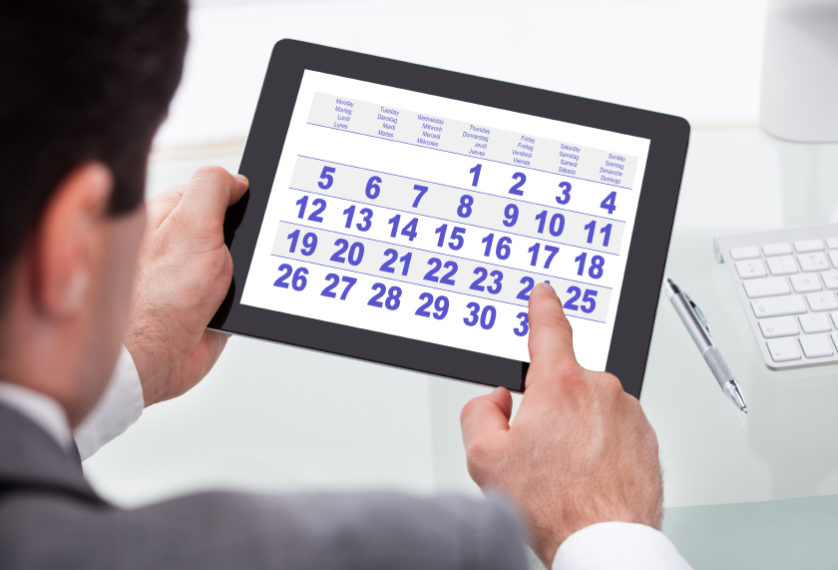 Businessman Looking At Calendar On Digital Tablet